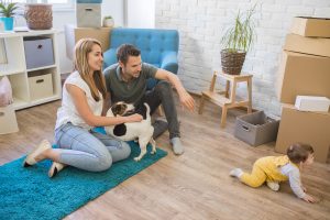 young family with a toddler girl and a pet dog moving in new home - pet safety tips for apartment living