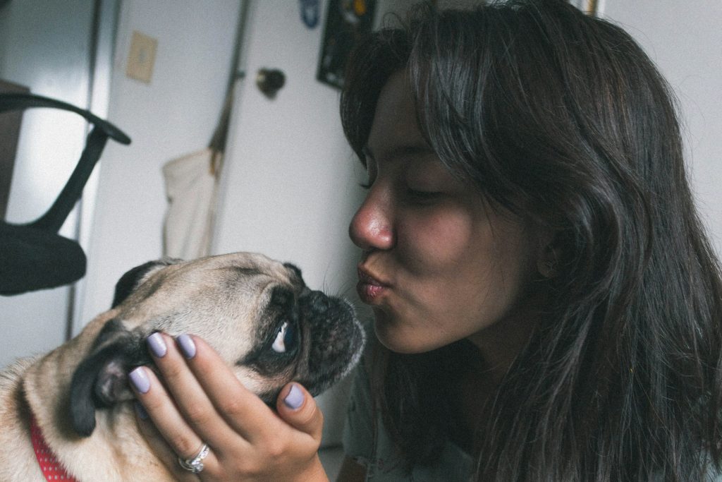 women about to kiss dog - keep a pet calm during a thunderstorm