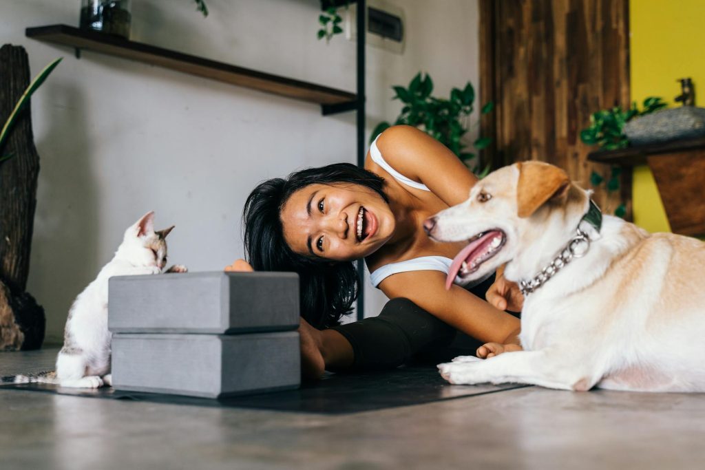 A Woman Doing Yoga at Home with her pets -