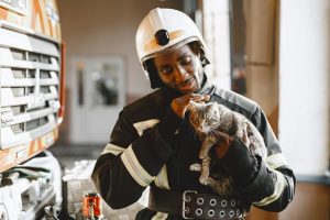 fireman holding a cat - pet emergency preparedness in apartments
